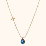 14K gold necklace with blue gemstone teardrop pendant and gold bird charm