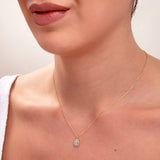 Close-up of woman wearing 14k gold teardrop necklace with pavé halo cubic zirconia pendant

