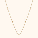 14K gold necklace with small textured bead accents on fine chain