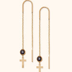 14k gold threader earrings with black round crystal and cross charm on soft background

