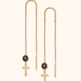 14k gold threader earrings with black round crystal and cross charm on soft background

