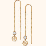 Delicate 14k gold threader earrings with faceted crystal and floral charm on light background

