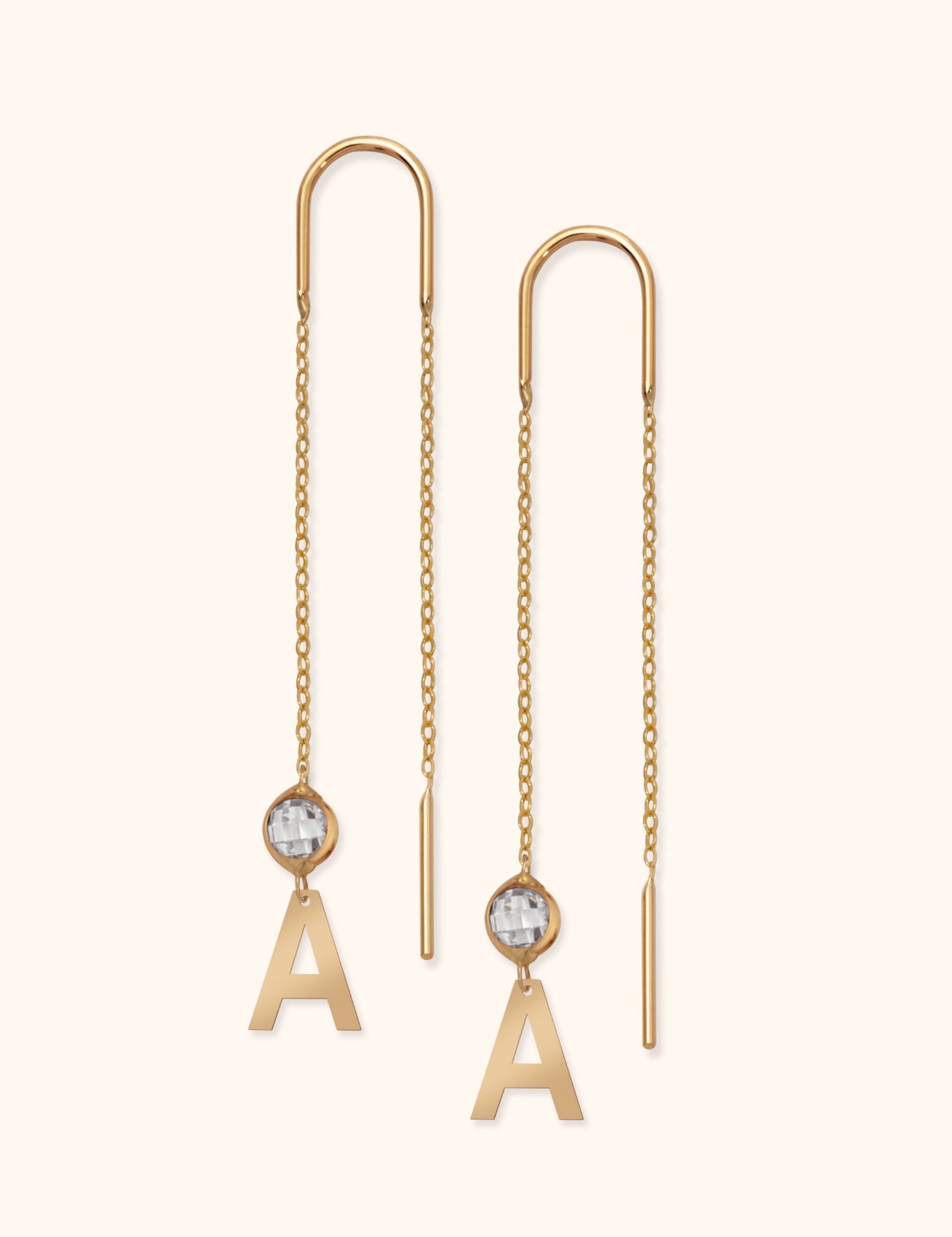 14k gold threader earrings with letter A charm and faceted crystal on light background

