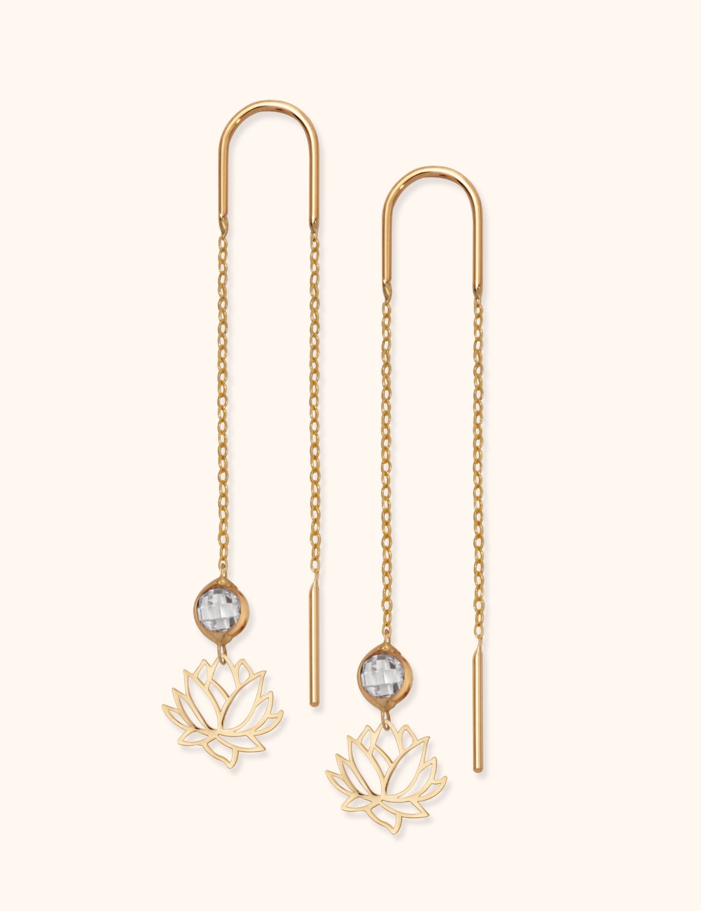 14k gold threader earrings with faceted crystal and lotus flower charm on light background

