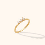 14K gold ring with three small pearls in minimalist stackable design, floating on neutral background