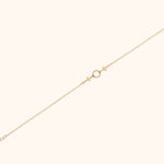 14K gold twin cross charm bracelet with center twisted circle on cream background