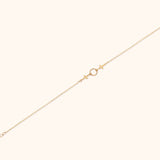 14K gold twin cross charm bracelet with center twisted circle on cream background