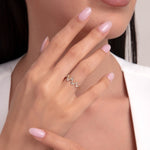 Close-up of a woman's hand wearing a 14K gold zigzag ring with clear cubic zirconia stones