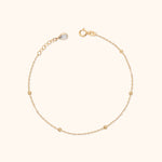 14K solid gold beaded bracelet with minimalist design on cream background