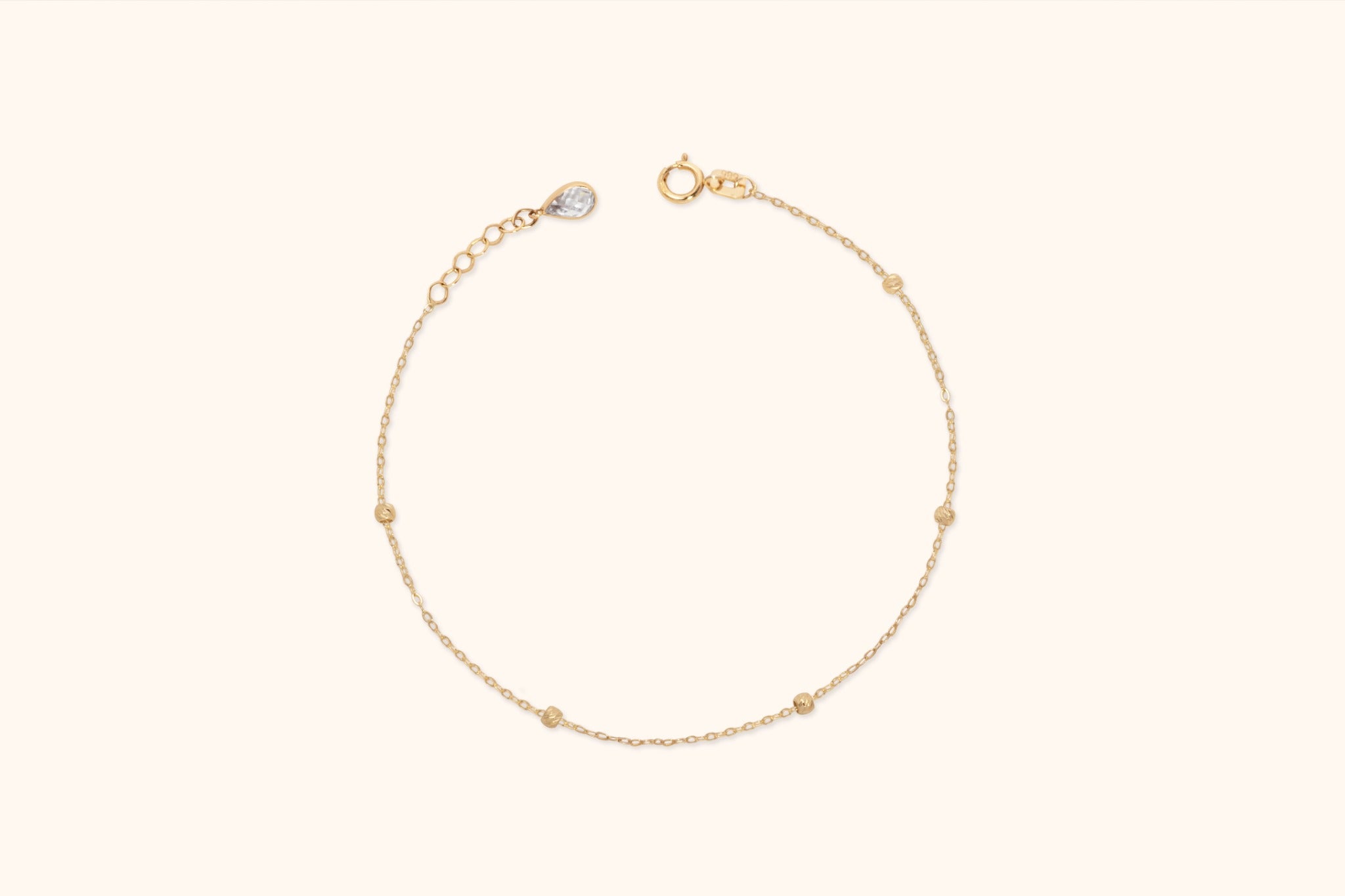 14K solid gold beaded bracelet with minimalist design on cream background