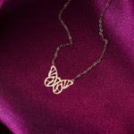 14K gold butterfly pendant necklace on fine chain, displayed on pink satin