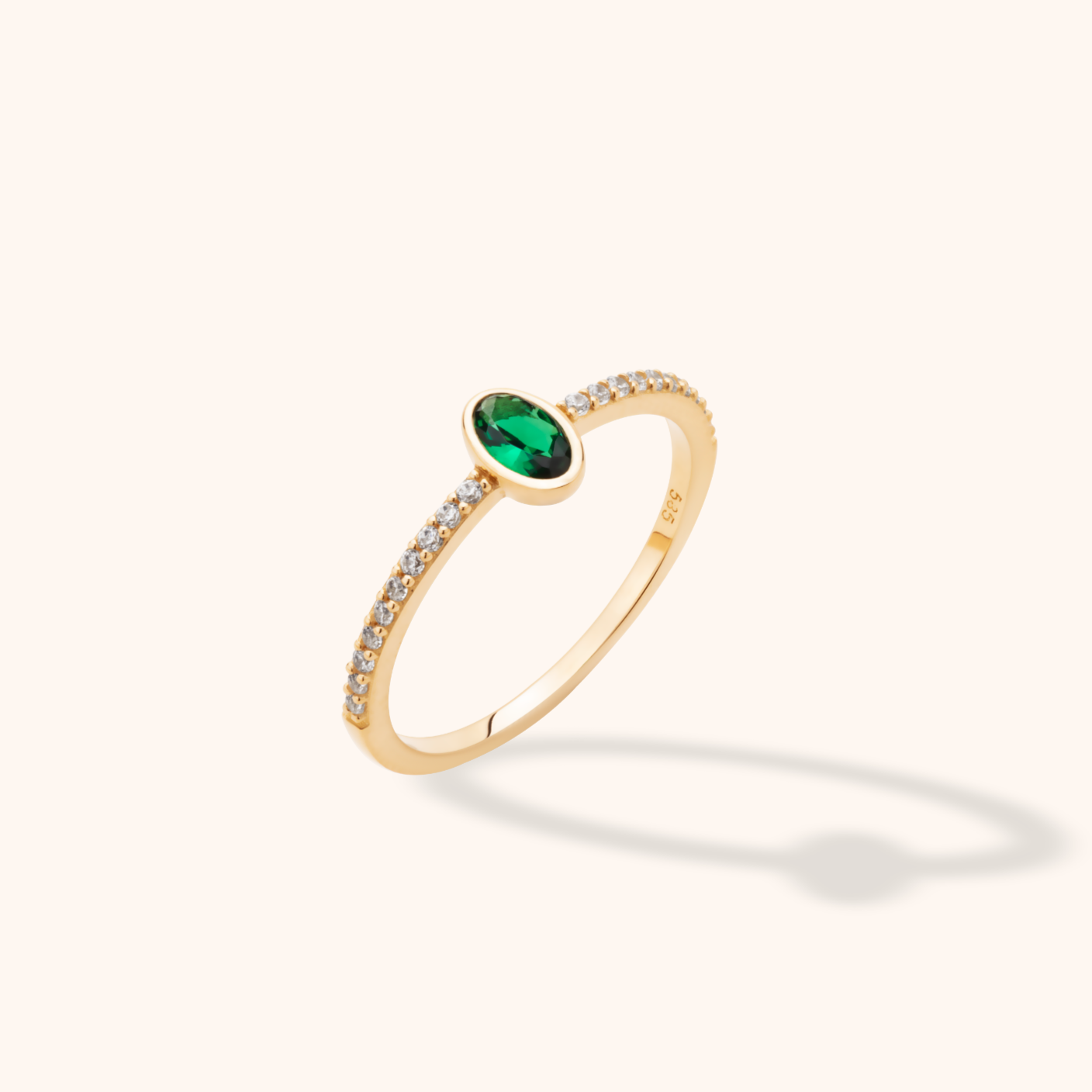 14K yellow gold pavé band ring with an oval green emerald center and baguette diamond accents on a light background
