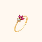 14K yellow gold ring with three marquise-cut rubies forming flower petals around a central round diamond halo, high-polish band