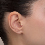 ear model wearing gold lightning bolt tragus earring cartilage piercing