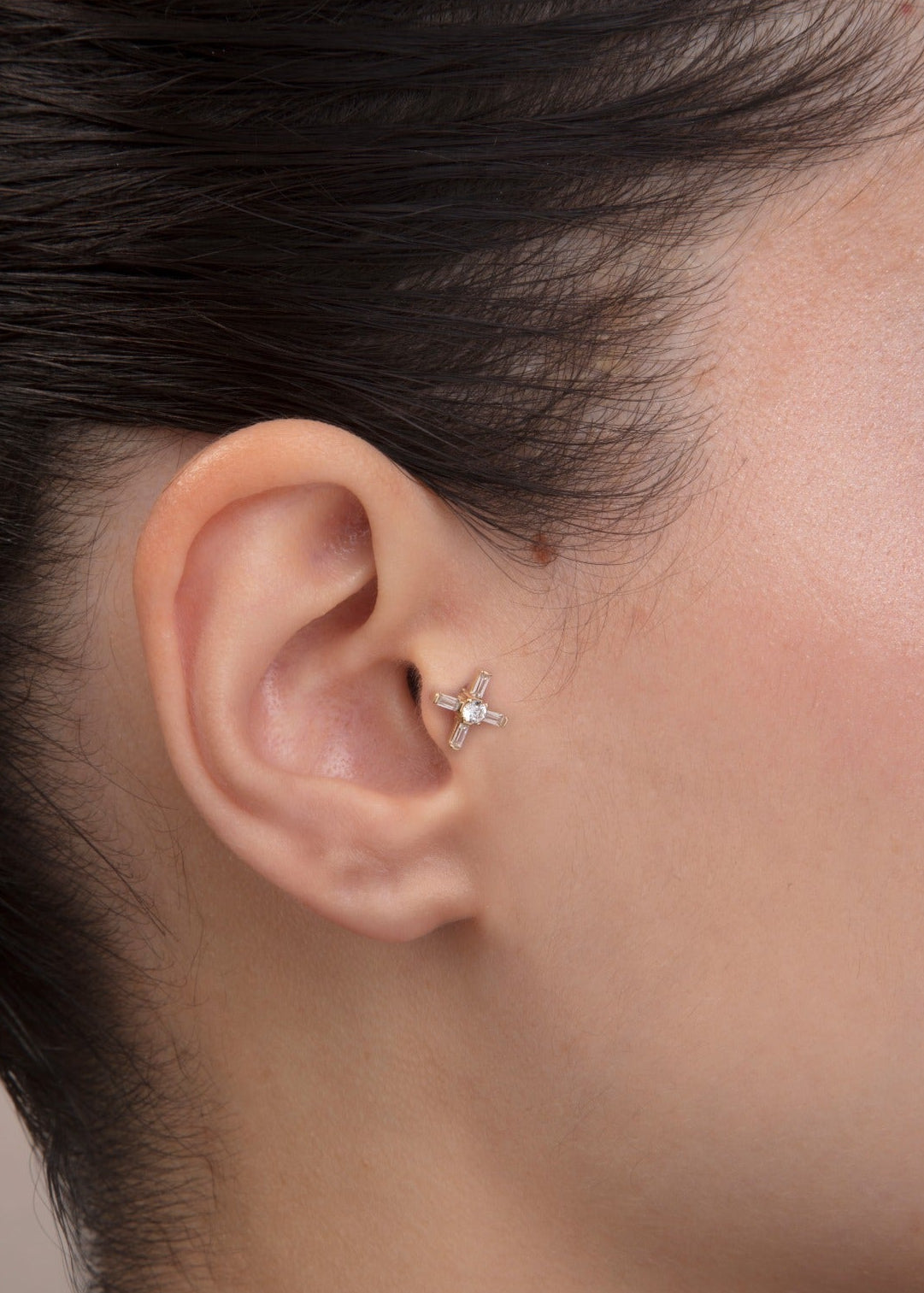 ear model wearing 14k gold baguette cz tragus earring cartilage piercing