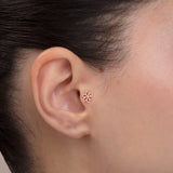 ear model wearing gold daisy tragus earring suitable for helix cartilage