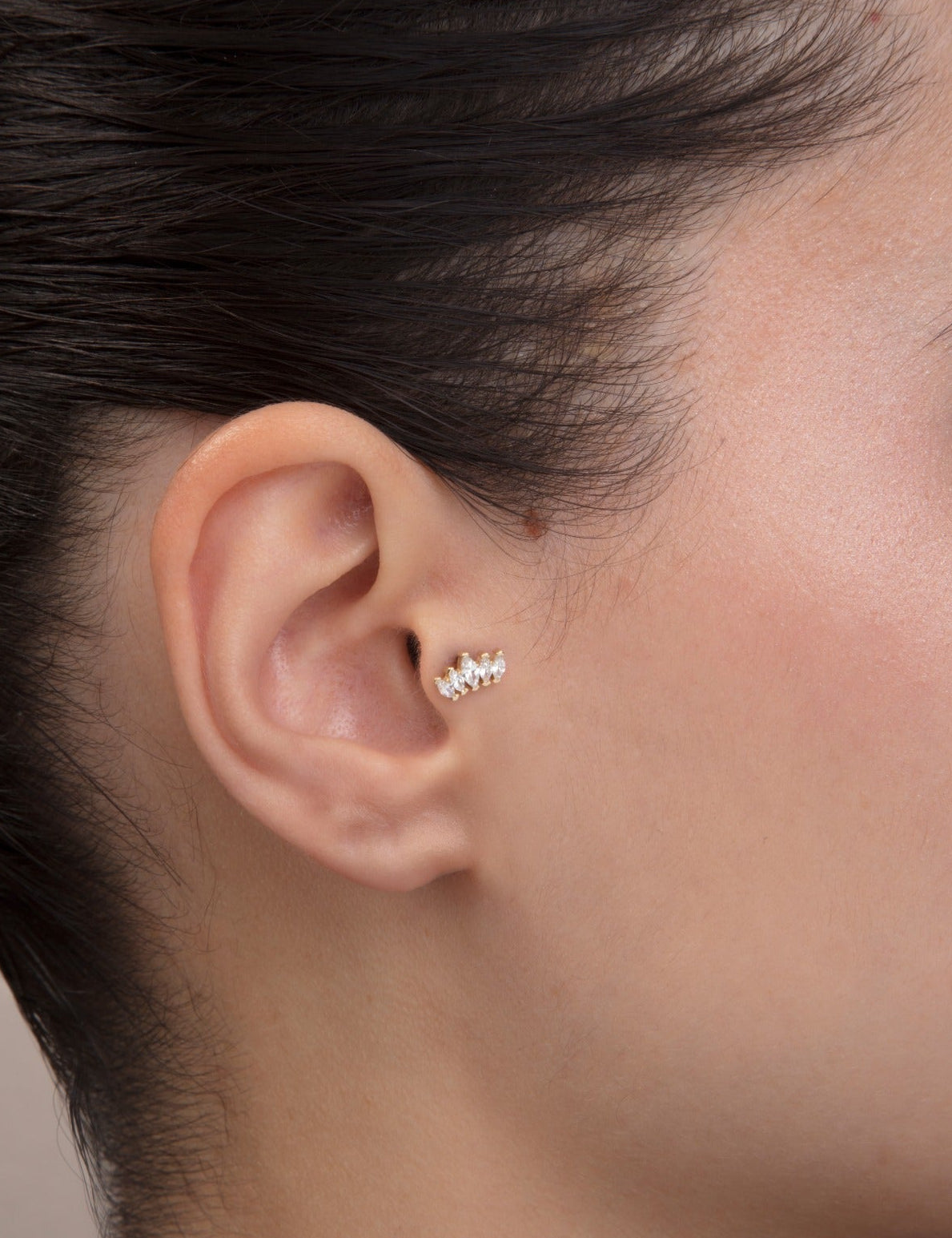 close-up of marquise stone cluster tragus stud in solid 14k gold flat back design