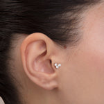 ear model wearing triple cz gold tragus earring cartilage piercing