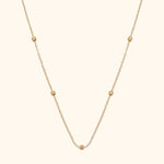 14K gold necklace with small textured bead accents on fine chain
