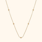 14K gold necklace with small textured bead accents on fine chain