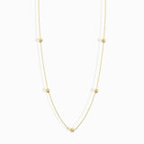 Minimalist 14K solid gold necklace with round beads spaced along a fine chain,