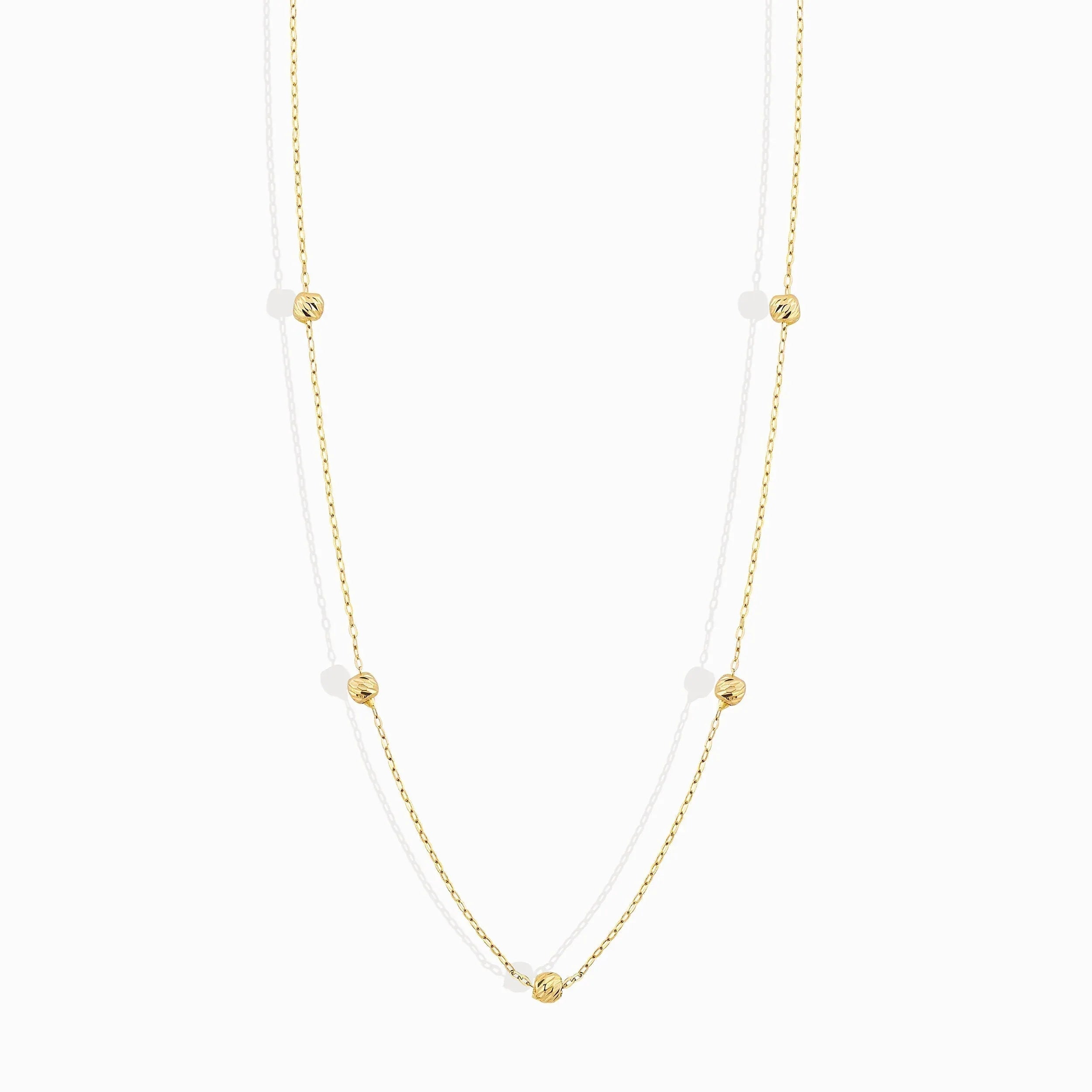 Minimalist 14K solid gold necklace with round beads spaced along a fine chain,