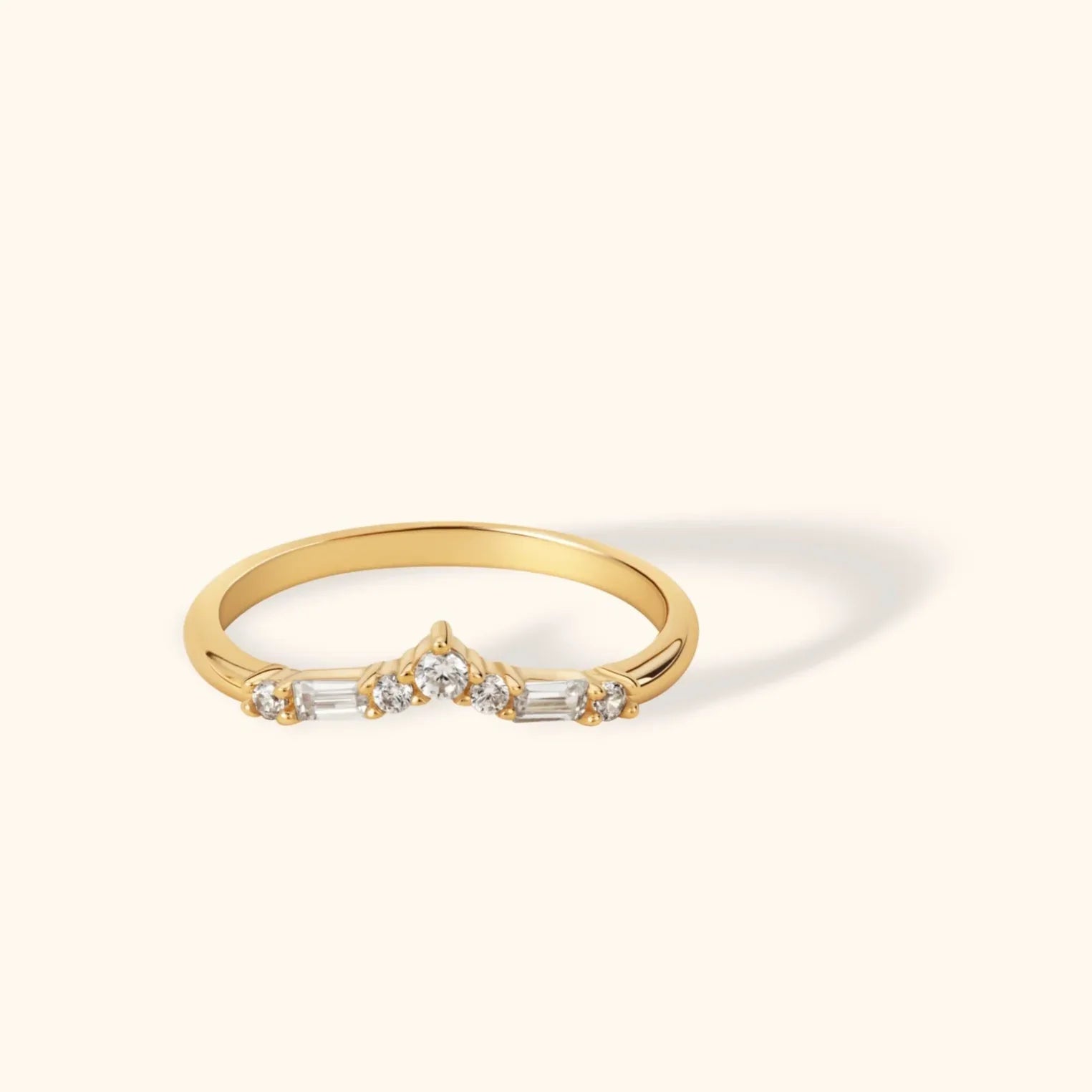 Chevron-shaped 14K gold ring featuring baguette and round zircon stones in a delicate curved design