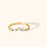 Chevron-shaped 14K gold ring featuring baguette and round zircon stones in a delicate curved design