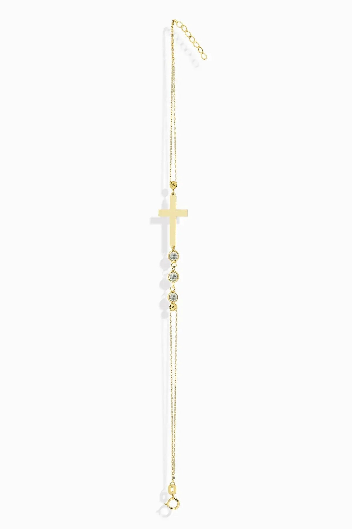 14K gold bracelet with minimalist cross and three small crystal beads, displayed white