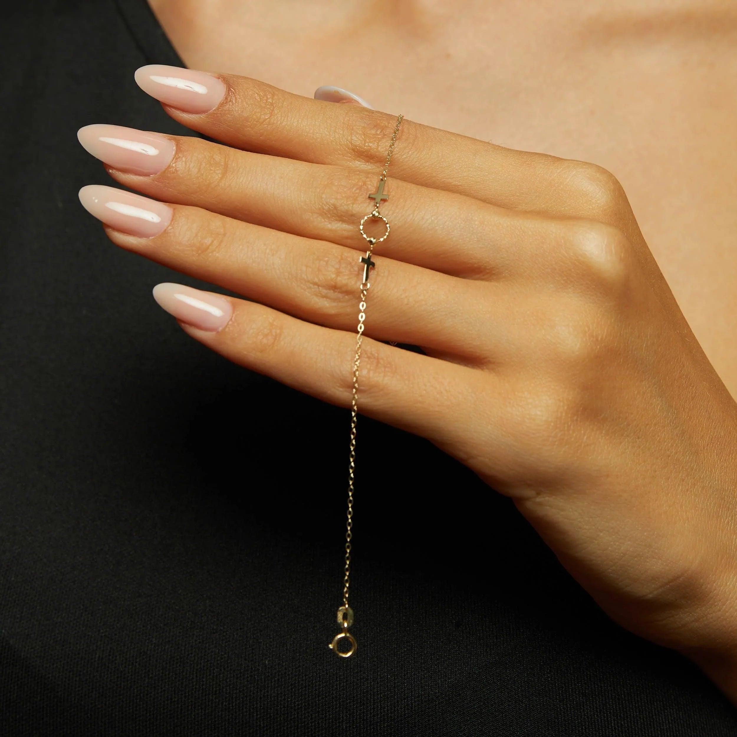 14K gold bracelet with two cross charms and a textured circular centerpiece