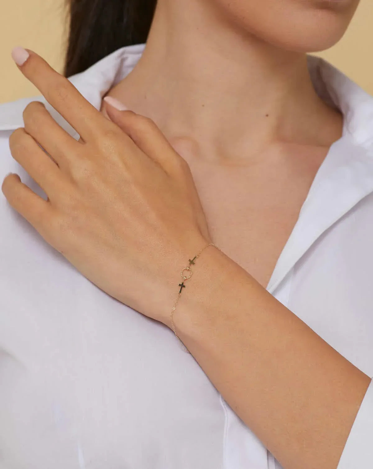 14K gold bracelet with two cross charms and a textured circular centerpiece