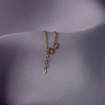 Elegant 14K gold bracelet with a cut-out seashell charm and faceted crystal beads, styled on rich emerald satin