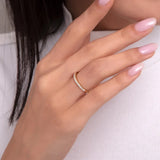 Elegant close-up of a woman wearing a half-eternity band with brilliant-cut diamonds set in a sleek 14K gold ring.
