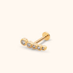 Gold-toned flat-back stud with five clear round accents in bezel settings, arranged in a gently curved row from large to small.