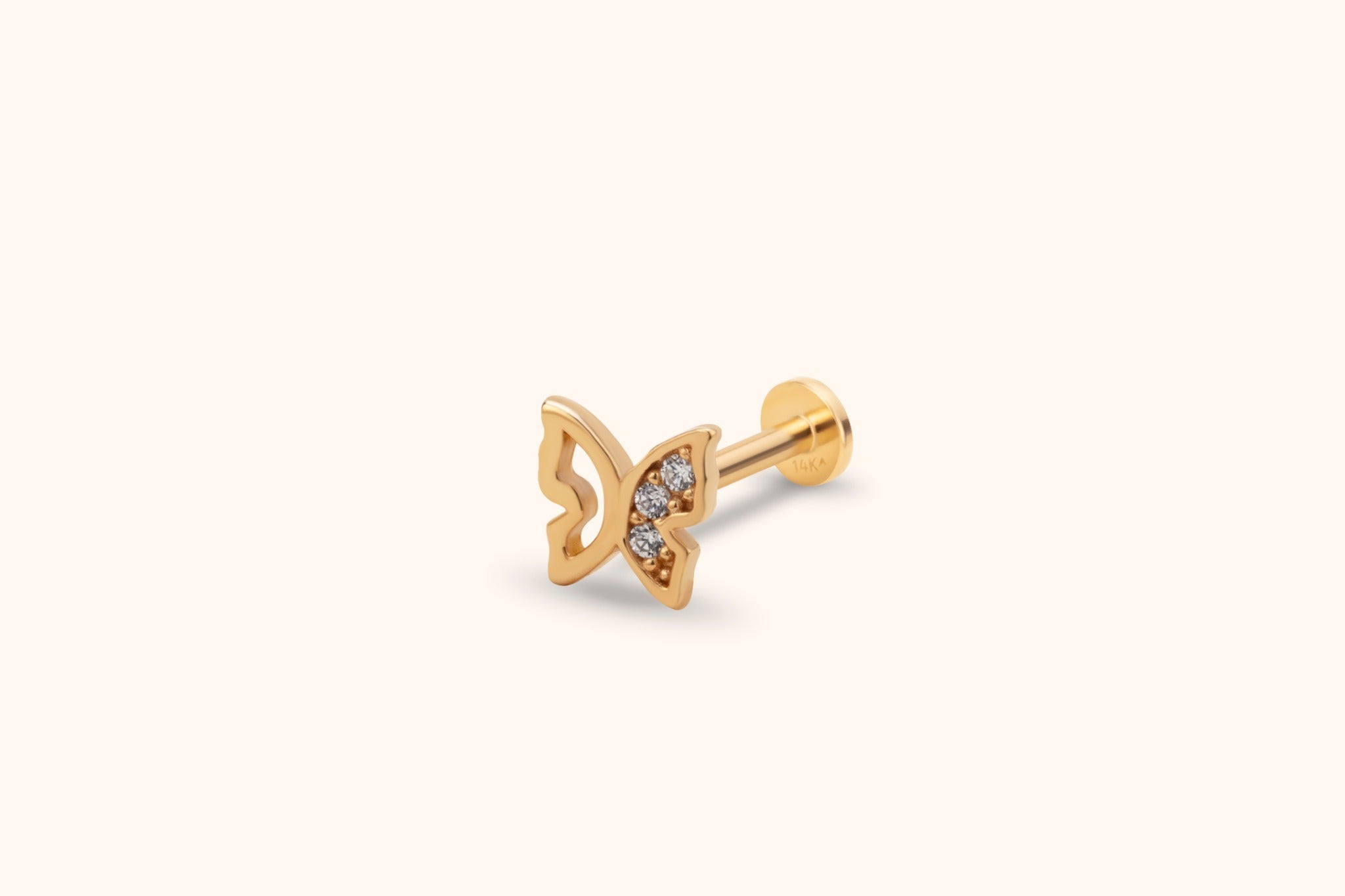Gold-tone butterfly stud with an openwork left wing, three clear accents on the right wing, and a round flat back.