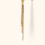 Gold-tone piercing stud with three clear accents on a slim bar, dangling chains of varied lengths, and a round flat back.