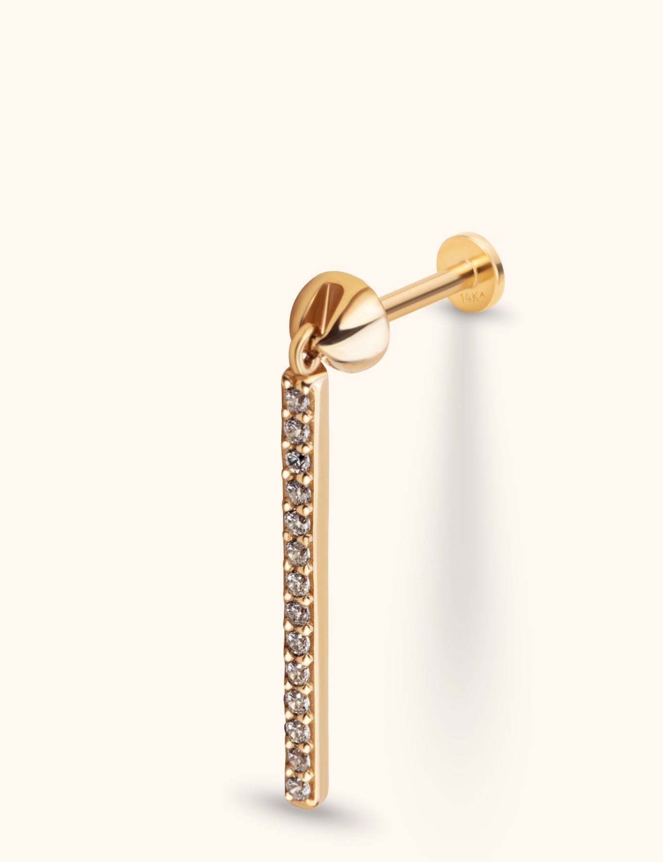 Gold-tone stud earring with a flat disc back and a long dangling bar lined with small, clear round stones.