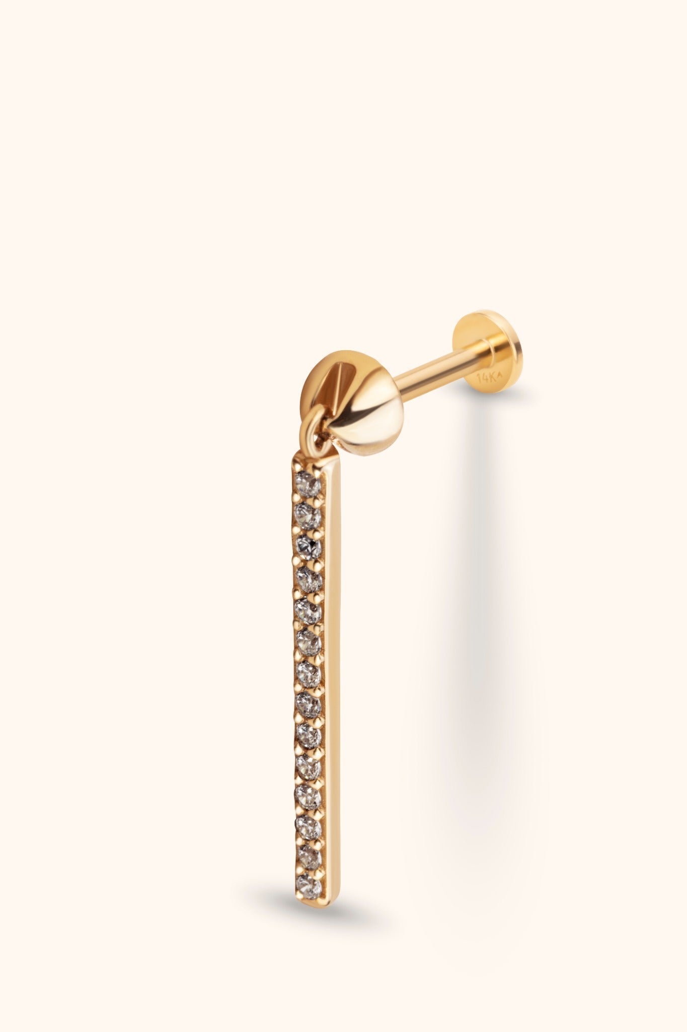 Gold-tone stud earring with a flat disc back and a long dangling bar lined with small, clear round stones.
