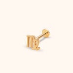 Gold-colored Virgo symbol stud earring with a straight post and flat round back, shown at an angle on a cream background.