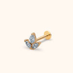 Gold-toned flat-back stud with a cluster of one pear-shaped and two marquise-shaped clear stones on a cream background.