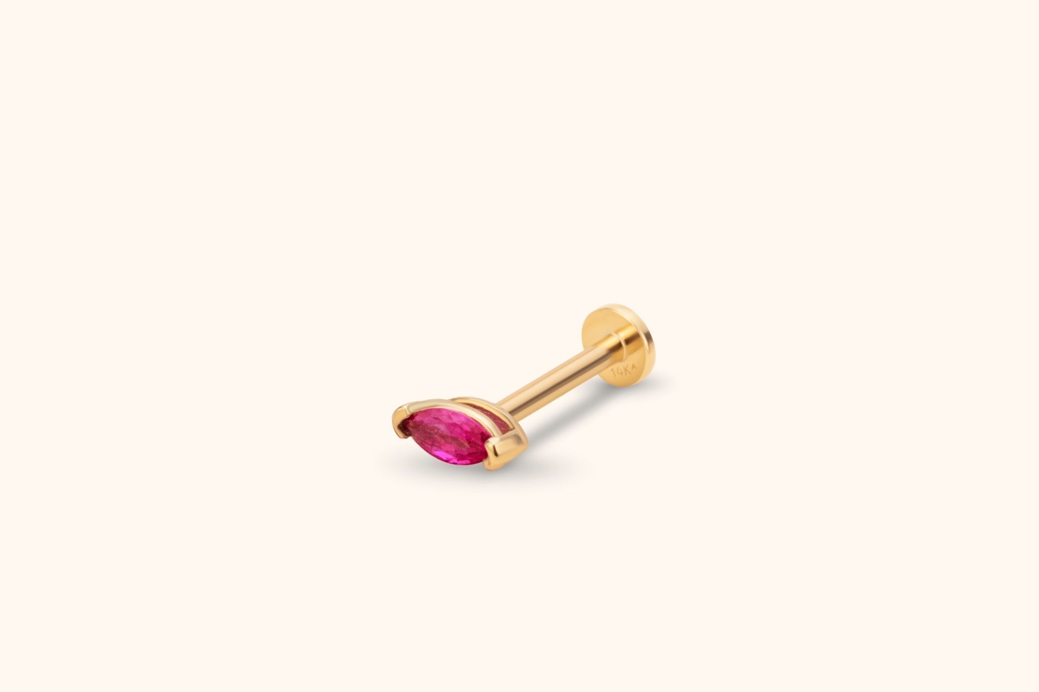 Gold-tone piercing stud with a faceted pink marquise-shaped stone, straight post and flat round back on a cream background.