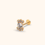 Gold-tone flat-back stud with a large round clear stone and two clusters of three smaller clear stones above and below.