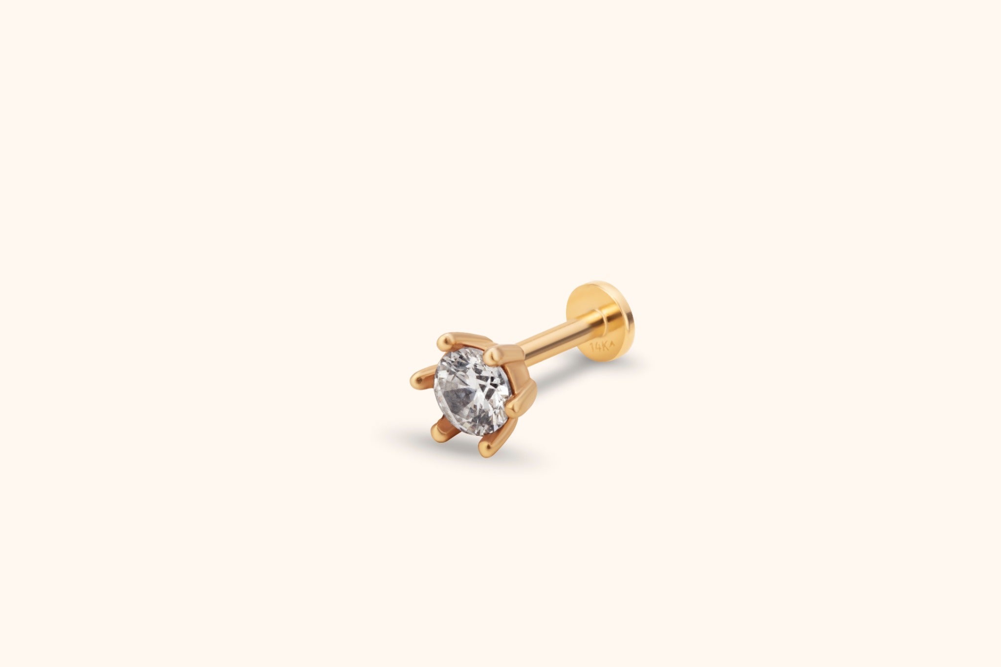 Gold-toned stud earring with a round clear faceted stone in a prong setting, a straight post and a flat circular back.
