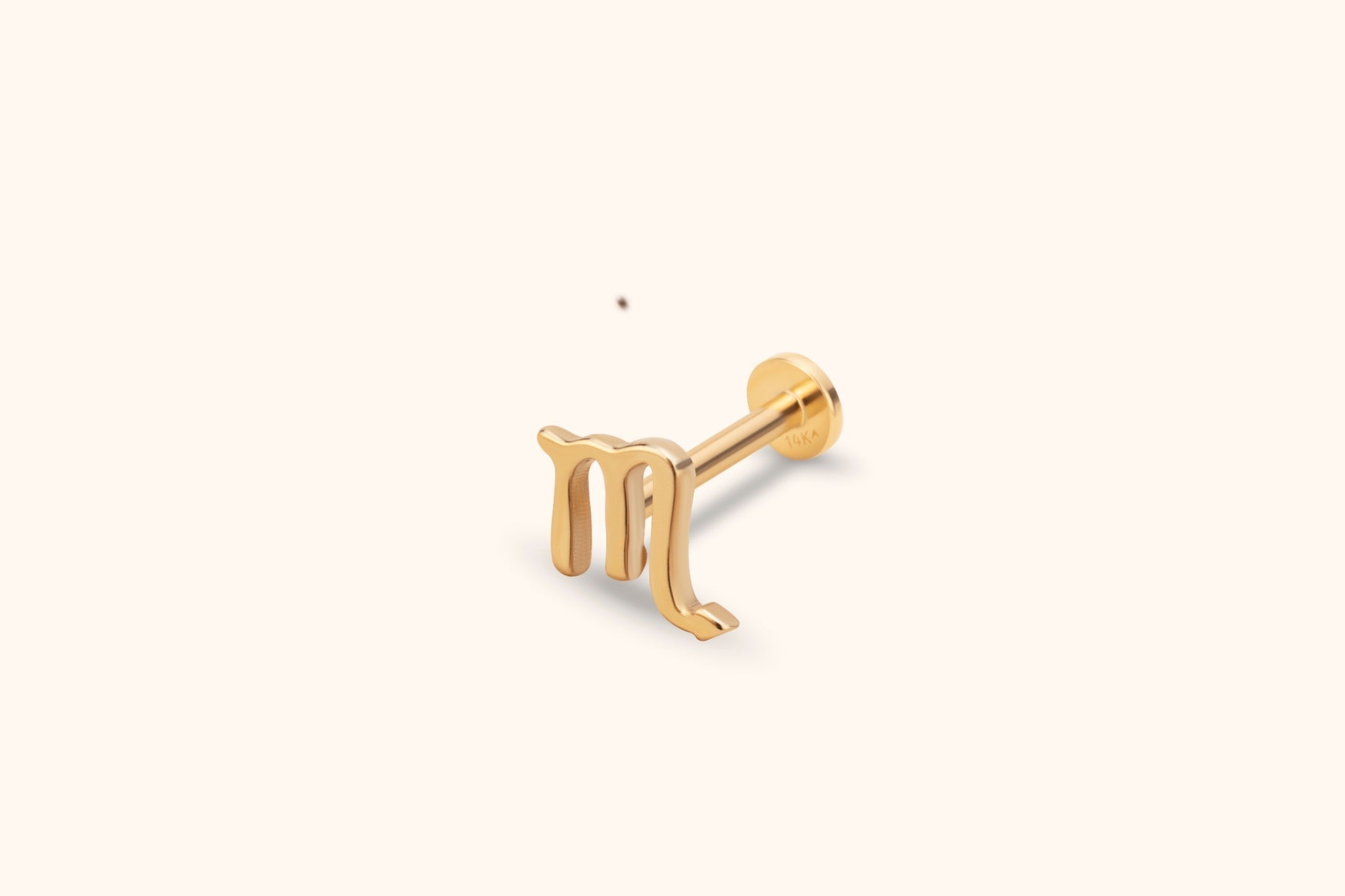 Gold-colored Scorpio symbol stud with a straight post and round flat back, shown at an angle on a cream background.