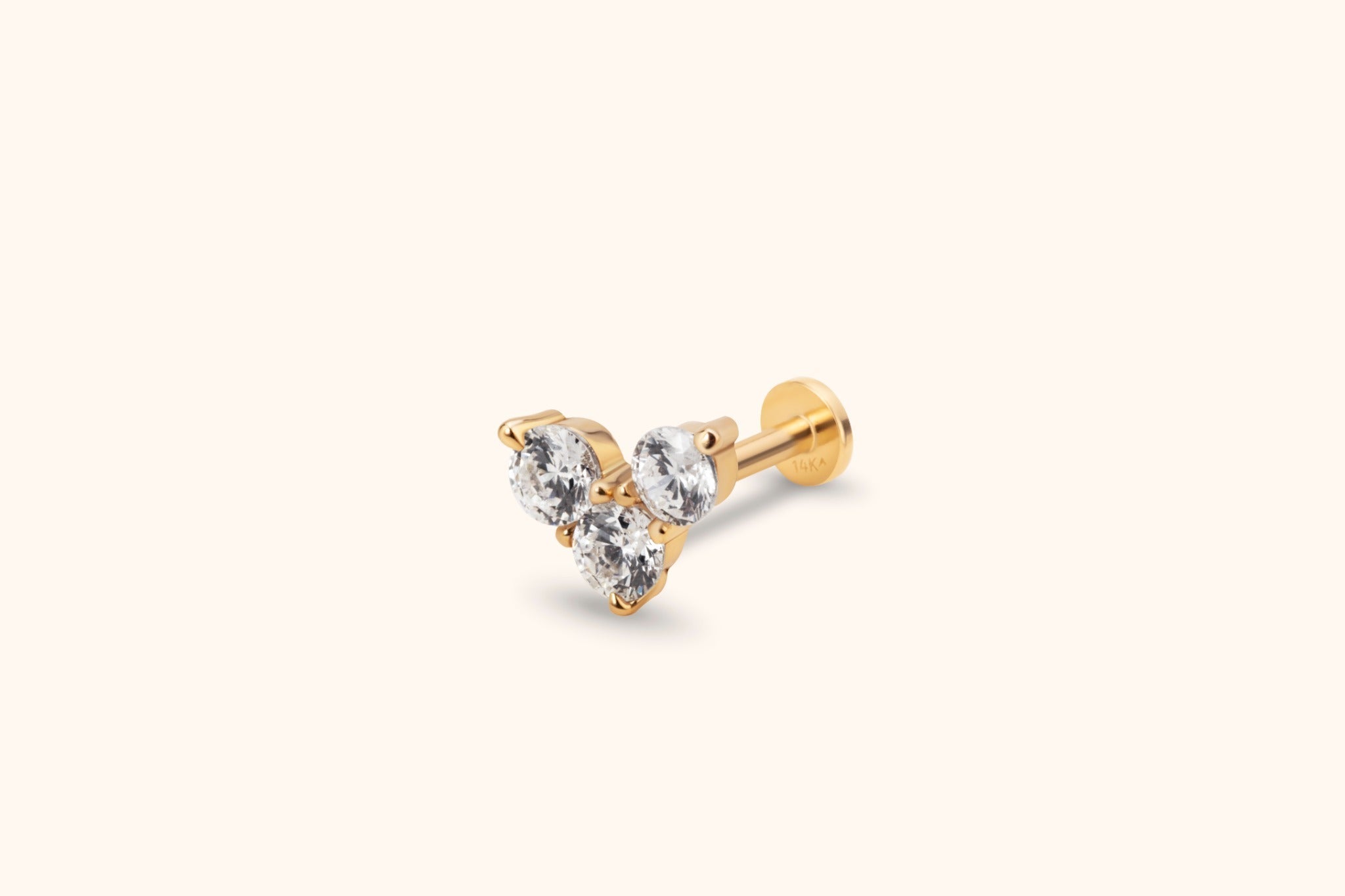 Gold-toned piercing stud with three clear faceted stones in a triangular cluster, a straight post and a flat round back.