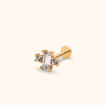 Gold-toned stud earring with a clear rectangular center stone flanked by two round stones, a straight post and flat disc back.