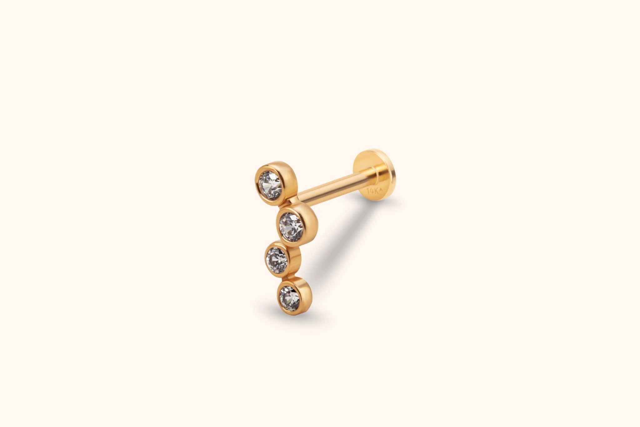 Gold-colored stud with four round clear stones in a staggered vertical row, a straight post and a flat circular back.