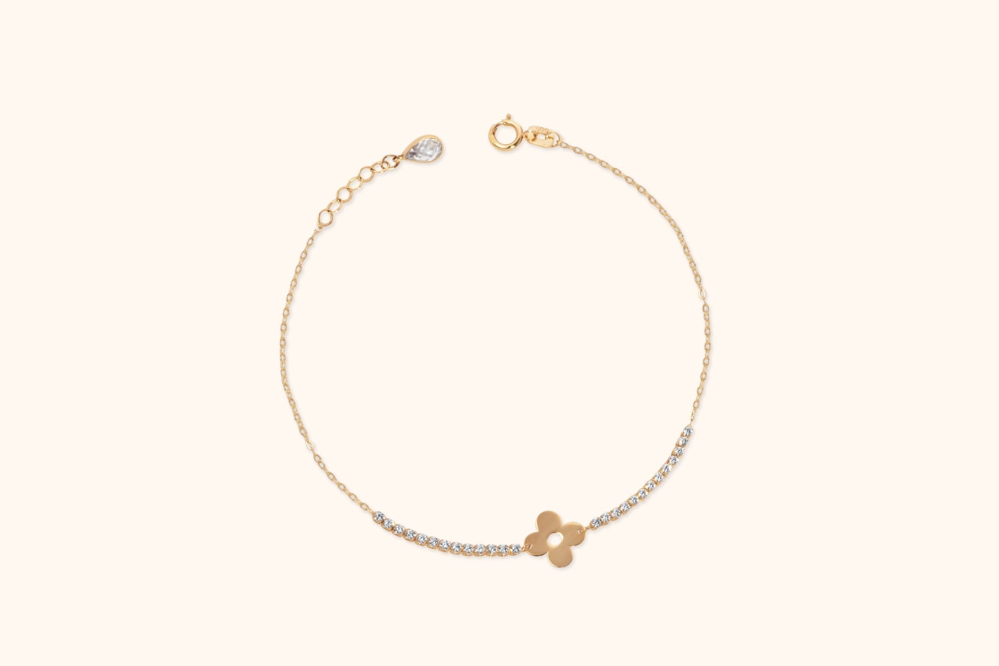 Gold-tone chain bracelet with a four-petal flower motif, clear round accents, an extender chain and a teardrop-shaped end charm.
