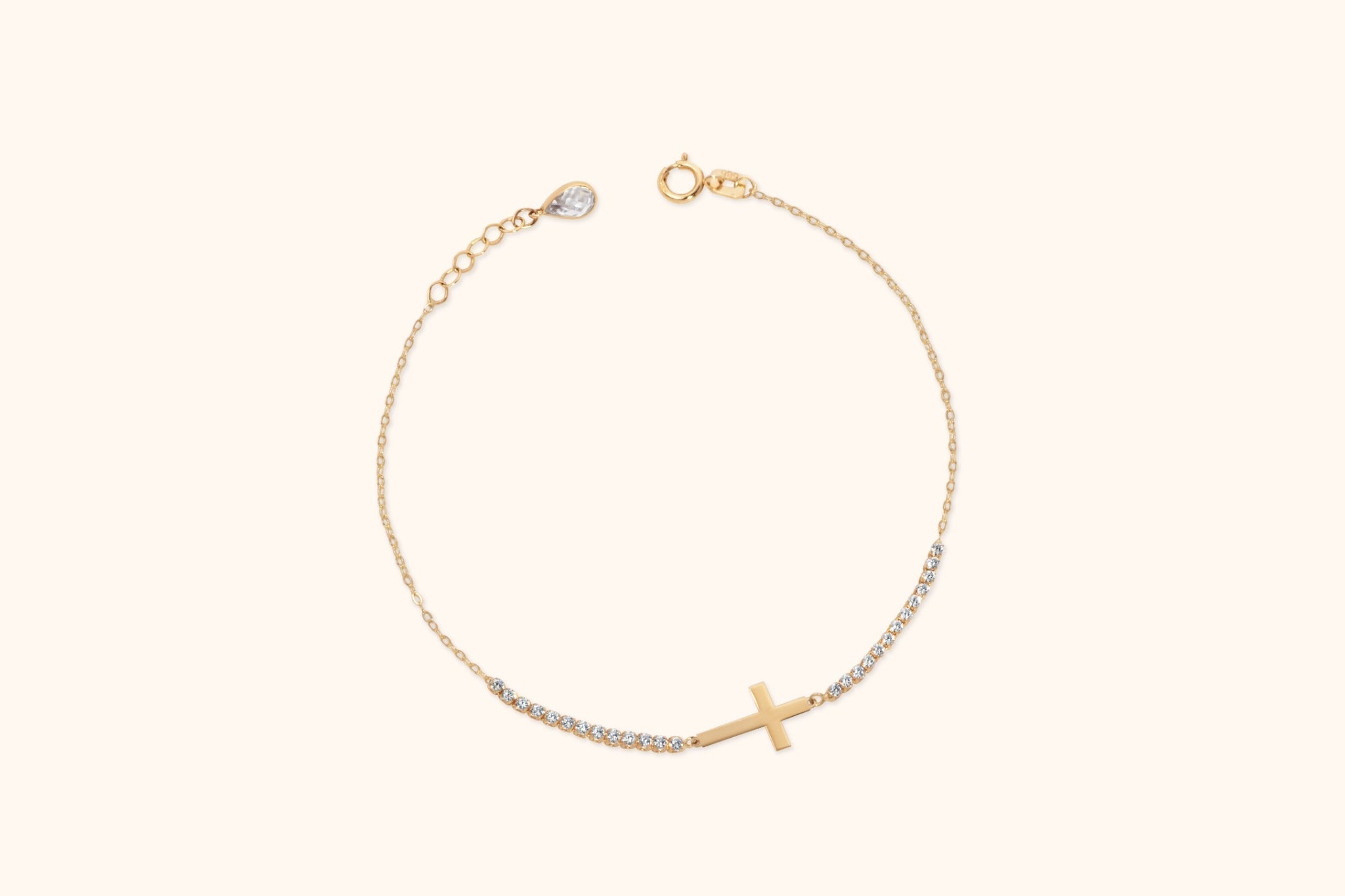 Gold-tone chain bracelet with a sideways cross, rows of clear accents, a round clasp and an extension chain with a teardrop charm.