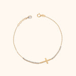 Gold-tone chain bracelet with a sideways cross, rows of clear accents, a round clasp and an extension chain with a teardrop charm.